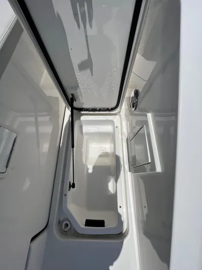  Yacht Photos Pics 2022 Sea Ray SLX 310 storage compartment with open lid, showcasing interior space.