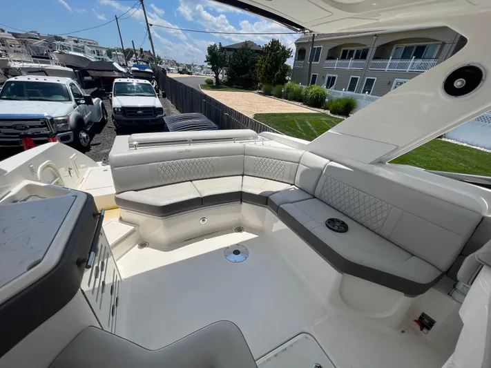  Yacht Photos Pics Luxurious seating area on a 2022 Sea Ray SLX 310 boat, parked near vehicles.
