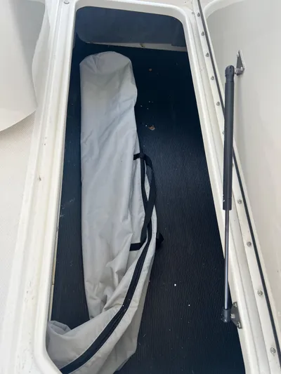  Yacht Photos Pics Storage compartment in a 2022 Sea Ray SLX 310 boat with a folded cover inside.