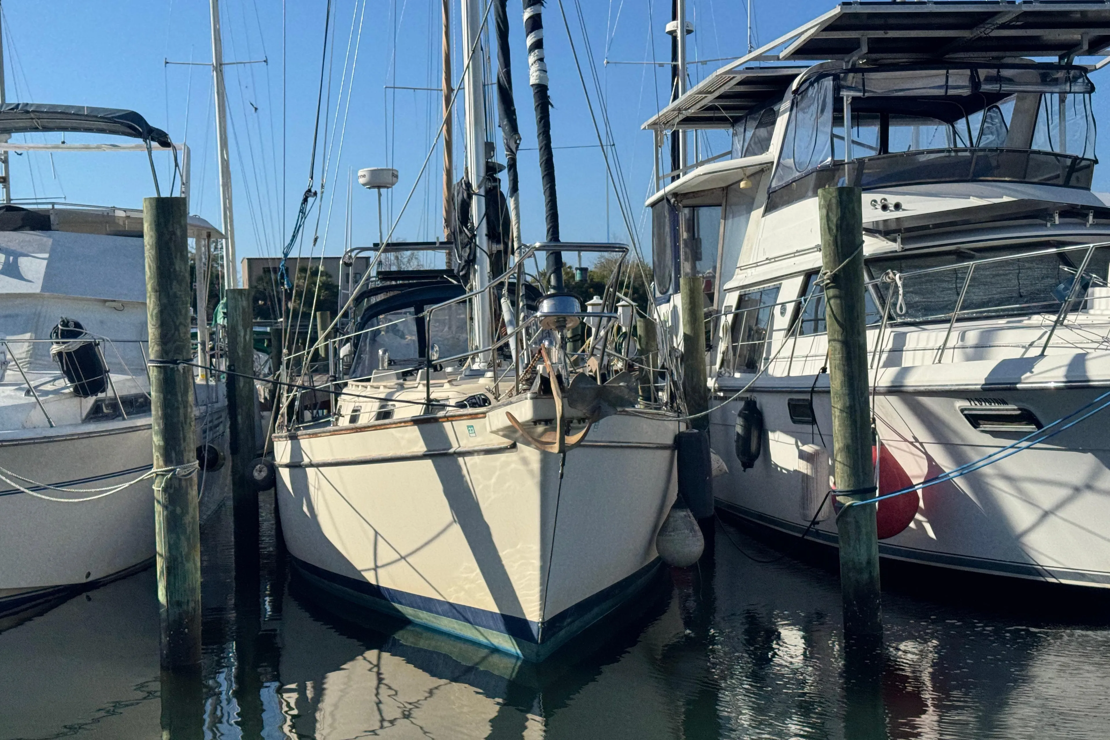 1991 Island Packet Yachts 38 docked between two boats in a marina.