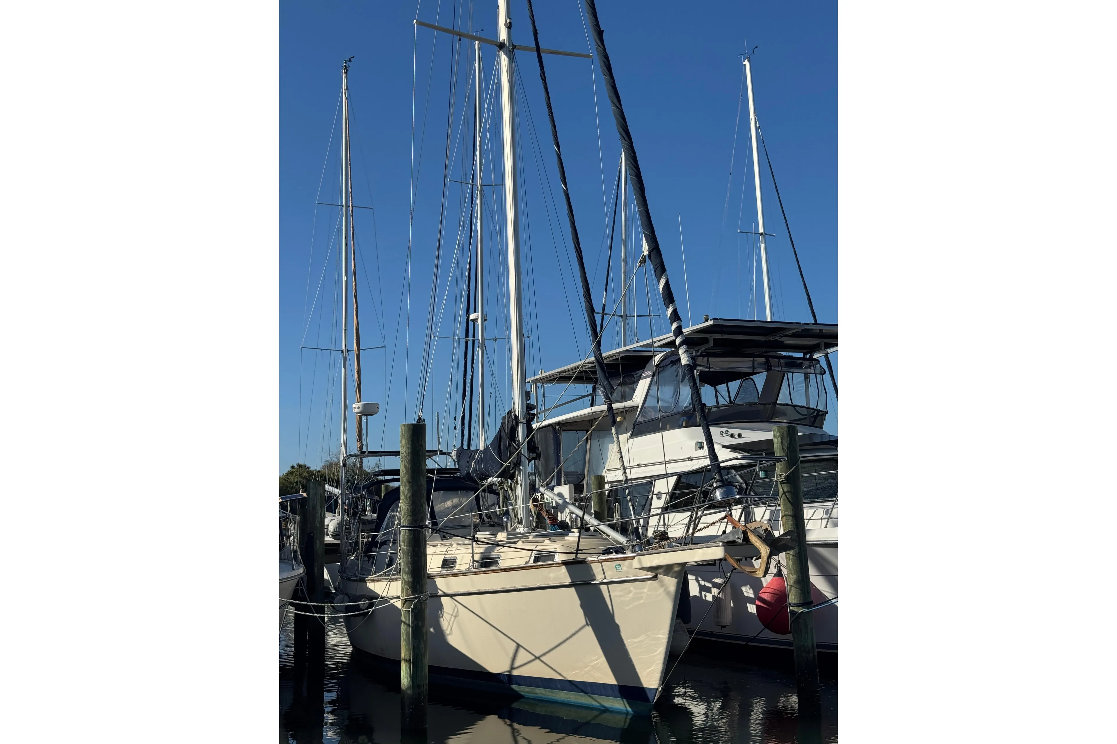 1991 Island Packet Yachts 38 sailboat docked at marina under clear blue sky.