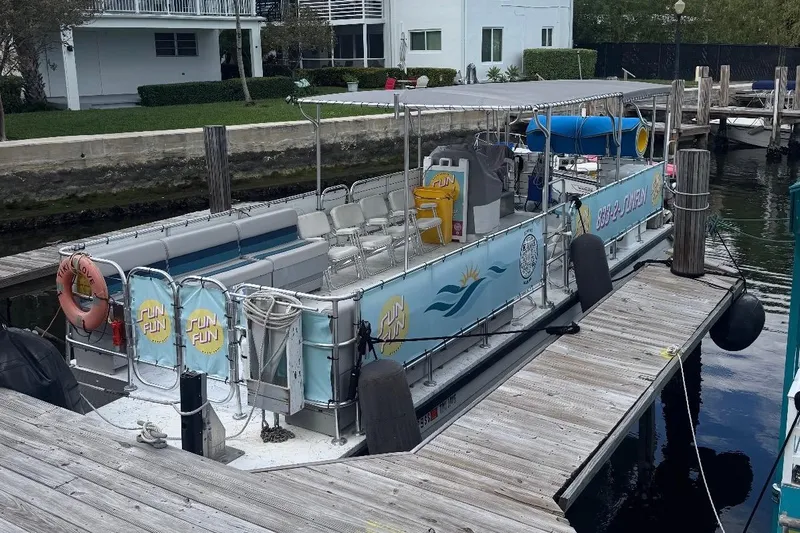 Tiki Love Yacht Photos Pics 2020 A&M Manufacturing 32 Pontoon docked, featuring seating and safety equipment.