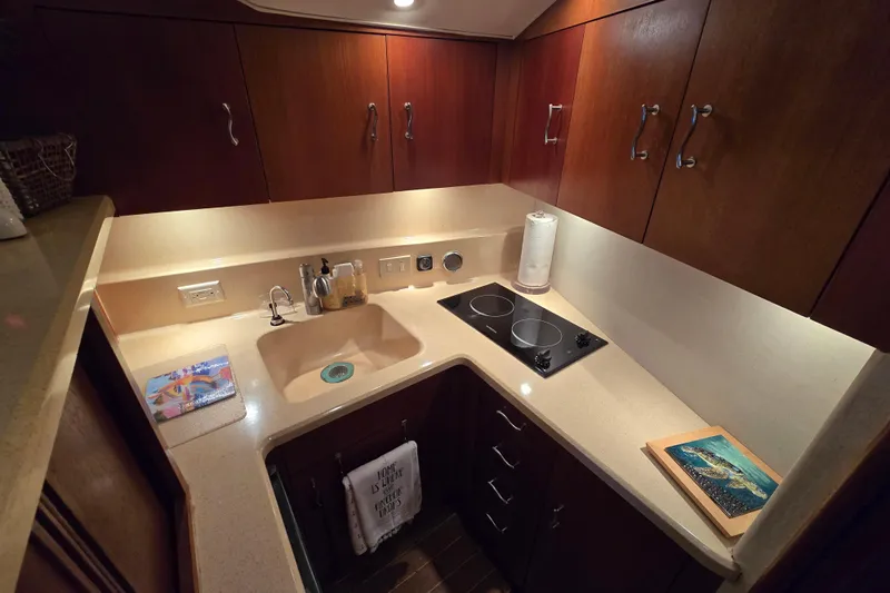  Yacht Photos Pics Kitchen area of 1999 Ocean Yachts 40 Open with sink, stove, and wooden cabinets.