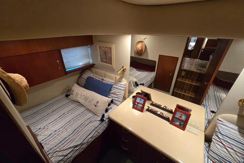  Yacht Photos Pics Cozy cabin interior of 1999 Ocean Yachts 40 Open, featuring striped bedding and nautical decor.
