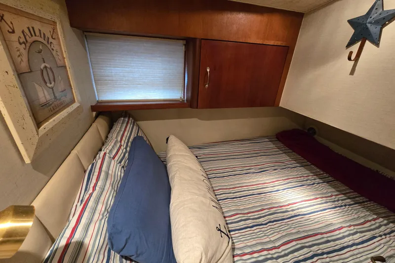  Yacht Photos Pics Cozy cabin interior of 1999 Ocean Yachts 40 Open, featuring striped bedding and nautical decor.