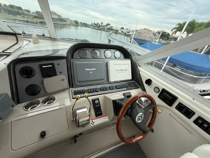 Yacht Photos Pics 2006 Sea Ray 40 Motor Yacht helm with Raymarine navigation system and wooden steering wheel.