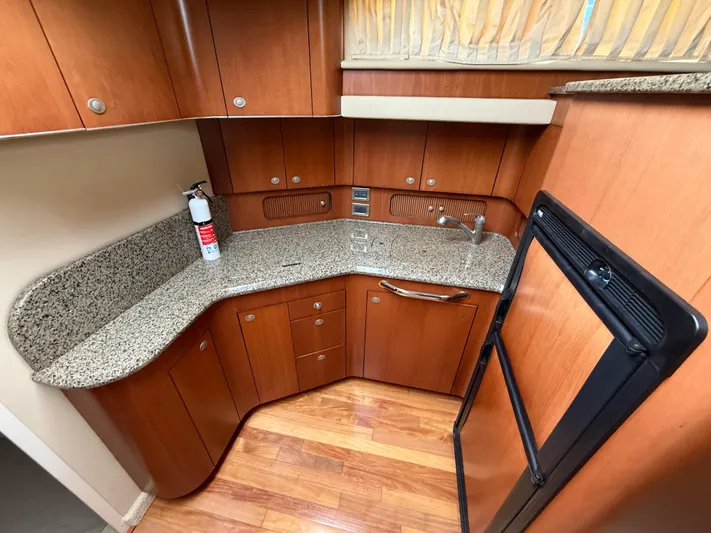  Yacht Photos Pics 2006 Sea Ray 40 Motor Yacht kitchen with granite countertops and wooden cabinetry.