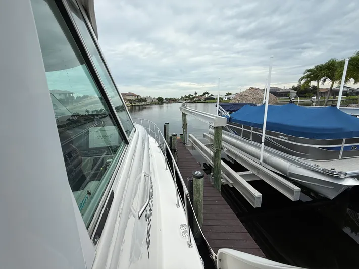  Yacht Photos Pics 2006 Sea Ray 40 Motor Yacht docked beside covered boat, cloudy sky.