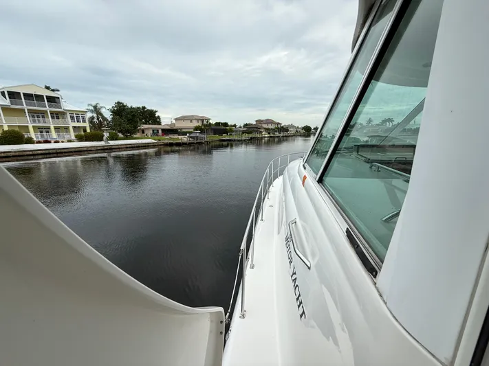 Yacht Photos Pics 2006 Sea Ray 40 Motor Yacht cruising along a serene waterfront neighborhood.