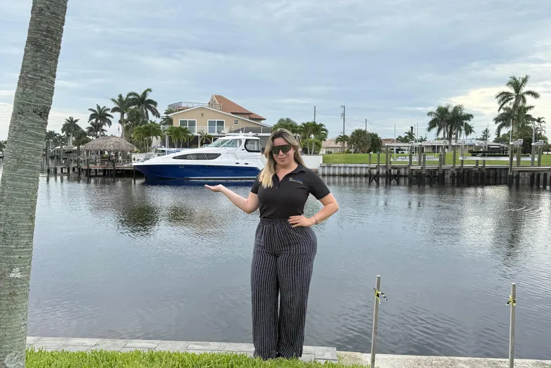 Yacht Photos Pics Woman posing by waterfront with 2006 Sea Ray 40 Motor Yacht in background.