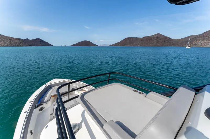 Fast Kash Yacht Photos Pics Boston Whaler 420 Outrage 2023 cruising in scenic blue waters with distant hills.