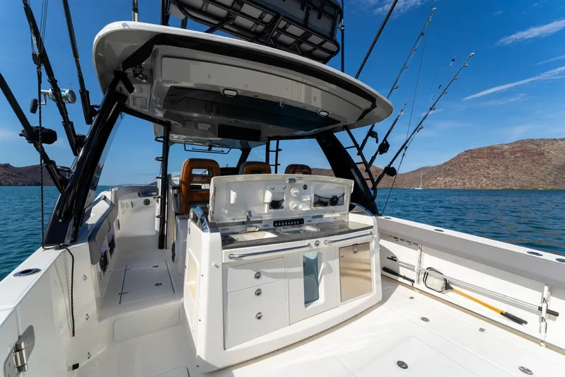 Fast Kash Yacht Photos Pics 2023 Boston Whaler 420 Outrage boat interior with fishing equipment on a sunny day.