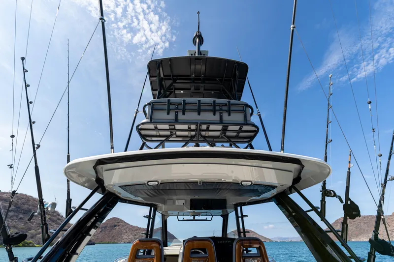 Fast Kash Yacht Photos Pics 2023 Boston Whaler 420 Outrage boat with fishing rods, ocean view, and clear blue sky.