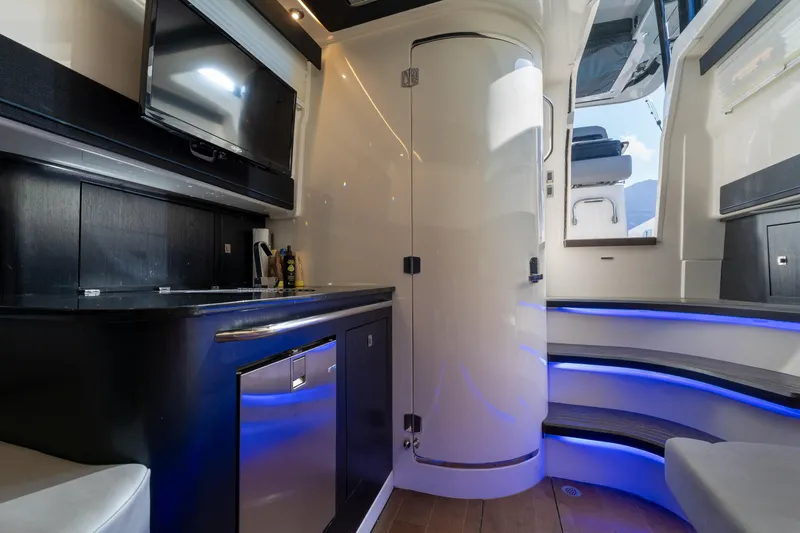 Fast Kash Yacht Photos Pics 2023 Boston Whaler 420 Outrage interior with modern kitchenette and ambient lighting.