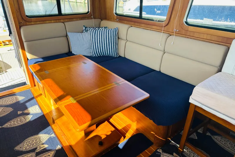 No Rush Yacht Photos Pics Interior of 2006 Sabre 42 Fly Bridge with cozy seating and wooden table.