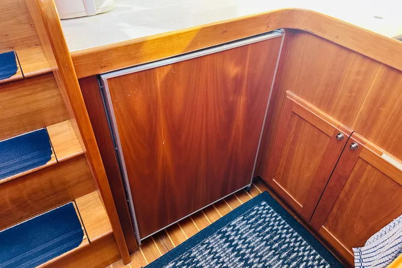 No Rush Yacht Photos Pics Wooden interior of 2006 Sabre 42 Fly Bridge yacht, featuring stairs and cabinetry.