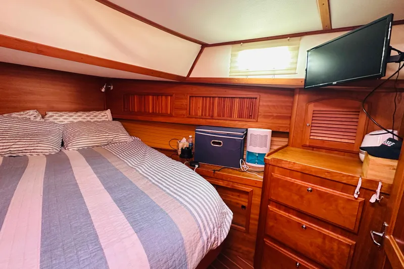 No Rush Yacht Photos Pics Cozy cabin interior of 2006 Sabre 42 Fly Bridge with bed, TV, and wooden storage.