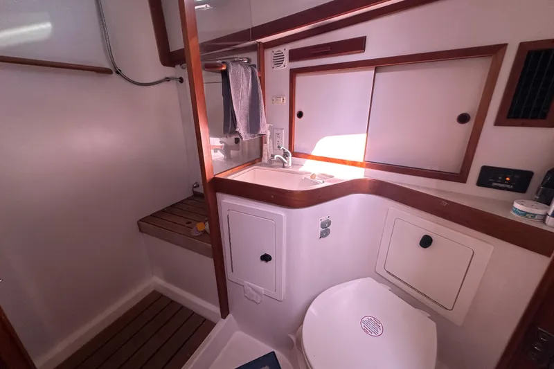No Rush Yacht Photos Pics 2006 Sabre 42 Fly Bridge yacht bathroom with sink, toilet, and wooden accents.