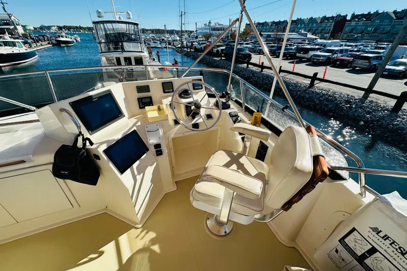 No Rush Yacht Photos Pics Flybridge of 2006 Sabre 42, featuring helm controls and navigation screens, docked at marina.
