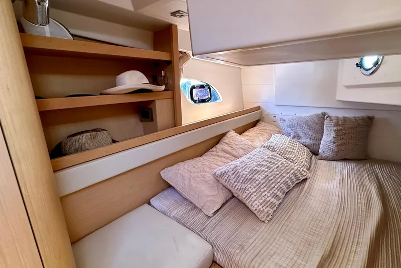  Yacht Photos Pics Cozy cabin interior of 2012 Beneteau Gran Turismo 34 with plush bedding and wooden shelves.