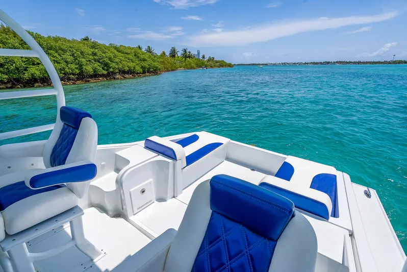  Yacht Photos Pics Nova 39 Sport 2020 boat with blue seating on clear turquoise water near lush shoreline.