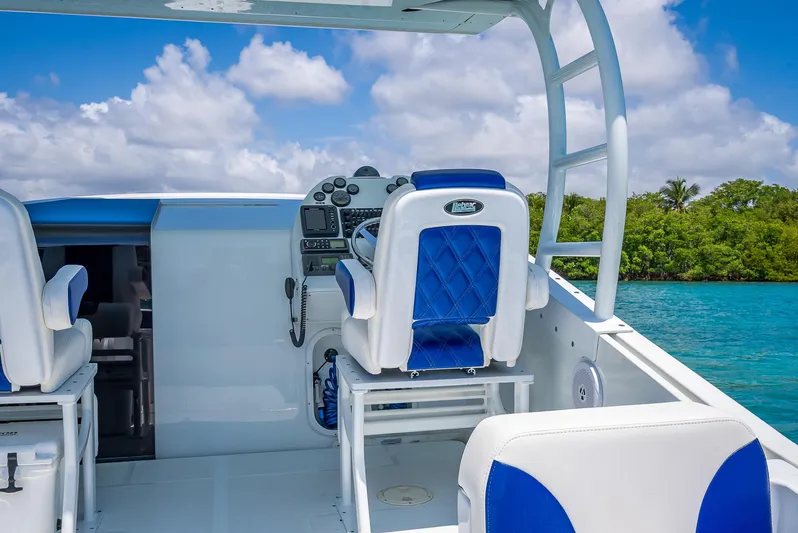  Yacht Photos Pics Nova 39 Sport 2020 boat interior with blue and white seating, steering console, and ocean view.