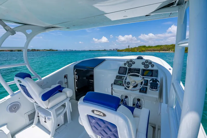  Yacht Photos Pics 2020 Nova 39 Sport boat cockpit with blue seats, steering wheel, and ocean view.