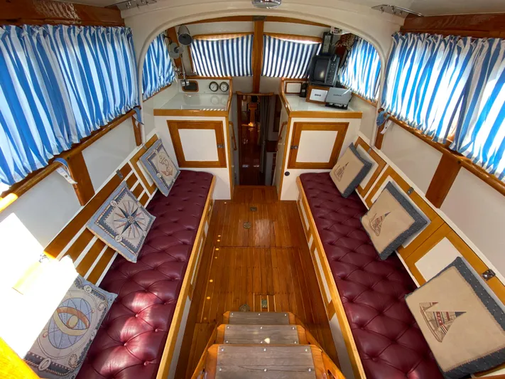 Windigo Yacht Photos Pics Interior of a 1956 Hinckley ocean racer with wood paneling and striped curtains.