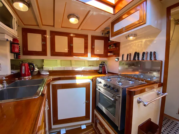 Windigo Yacht Photos Pics Vintage 1956 Hinckley ocean racer kitchen with wood cabinetry and modern appliances.