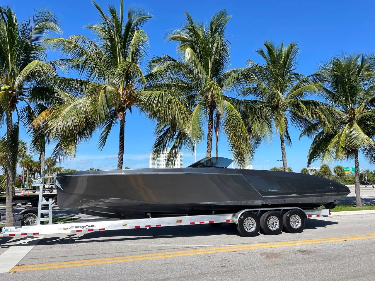 2020 Frauscher 1017 GT boat on a trailer, parked by palm trees.