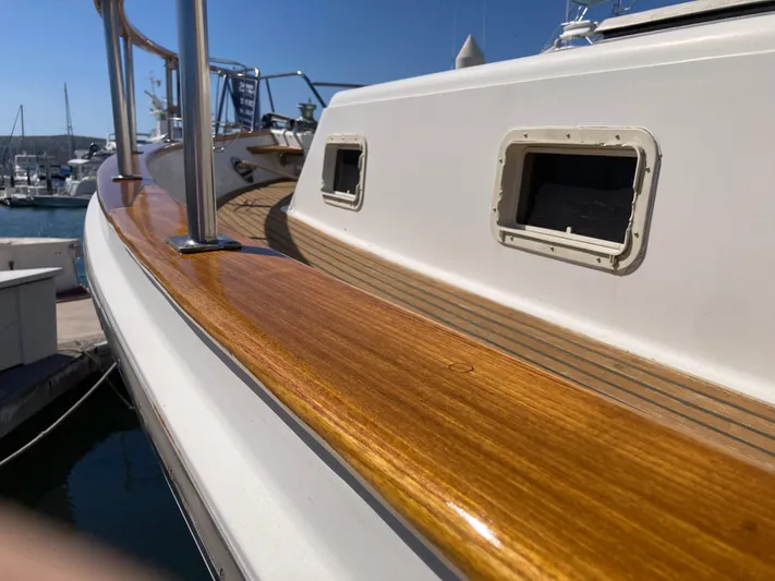  Yacht Photos Pics 1985 Offshore Yachts 48 Yachtfisher with polished wood railing, docked at marina.