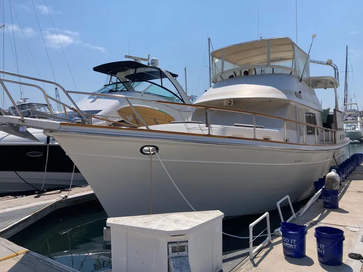  Yacht Photos Pics 1985 Offshore Yachts 48 Yachtfisher docked at marina under clear blue sky.