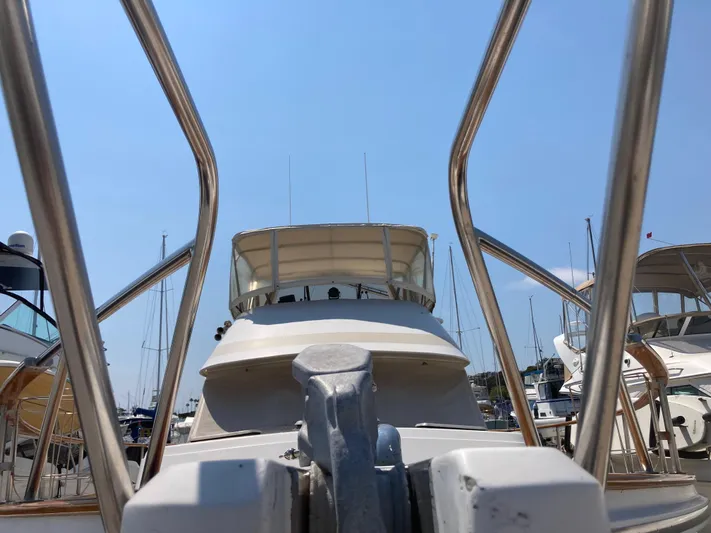  Yacht Photos Pics 1985 Offshore Yachts 48 Yachtfisher at marina, viewed from bow with clear blue sky.