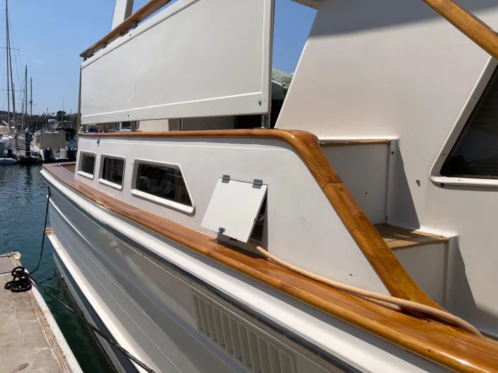 Yacht Photos Pics 1985 Offshore Yachts 48 Yachtfisher docked, showcasing sleek design and wooden railings.