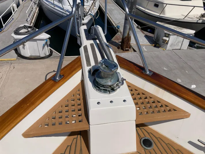  Yacht Photos Pics Bow of 1985 Offshore Yachts 48 Yachtfisher, featuring anchor winch and teak accents at dock.