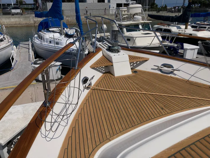  Yacht Photos Pics 1985 Offshore Yachts 48 Yachtfisher docked, showcasing teak deck and marina surroundings.