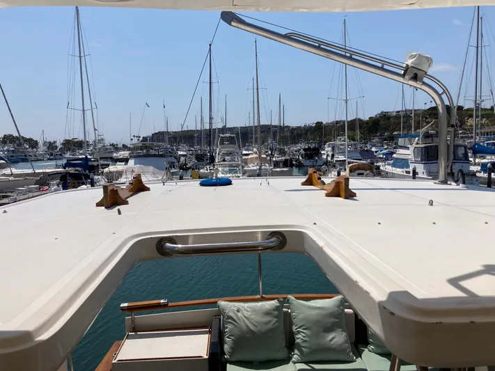  Yacht Photos Pics 1985 Offshore Yachts 48 Yachtfisher docked in a marina, surrounded by sailboats.