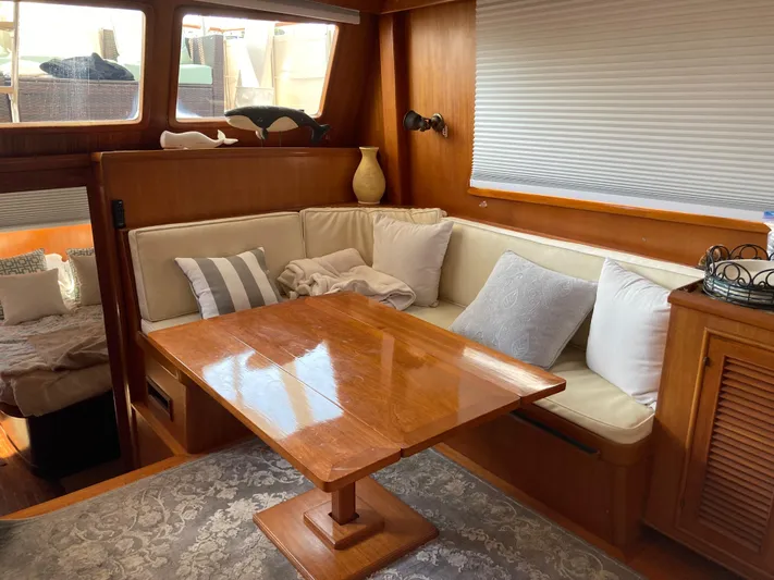 Yacht Photos Pics Interior of 1985 Offshore Yachts 48 Yachtfisher with cozy seating and wooden table.
