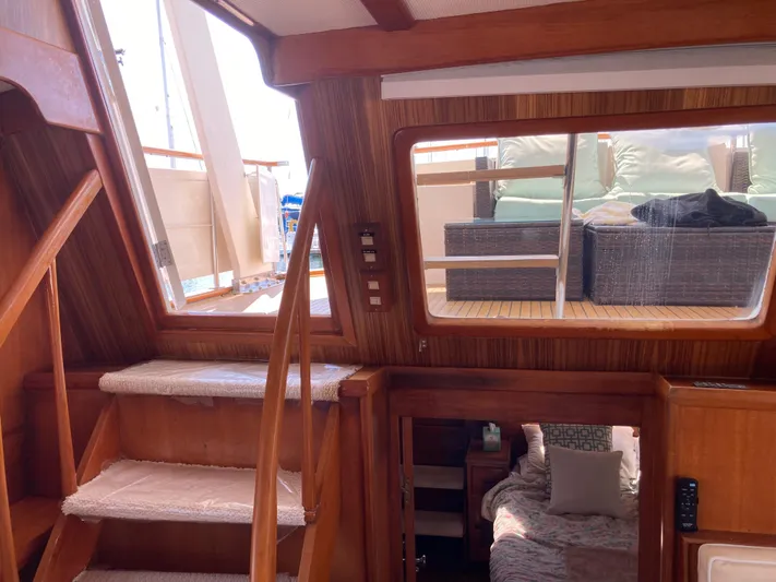  Yacht Photos Pics Interior view of 1985 Offshore Yachts 48 Yachtfisher, featuring wooden stairs and cozy cabin.