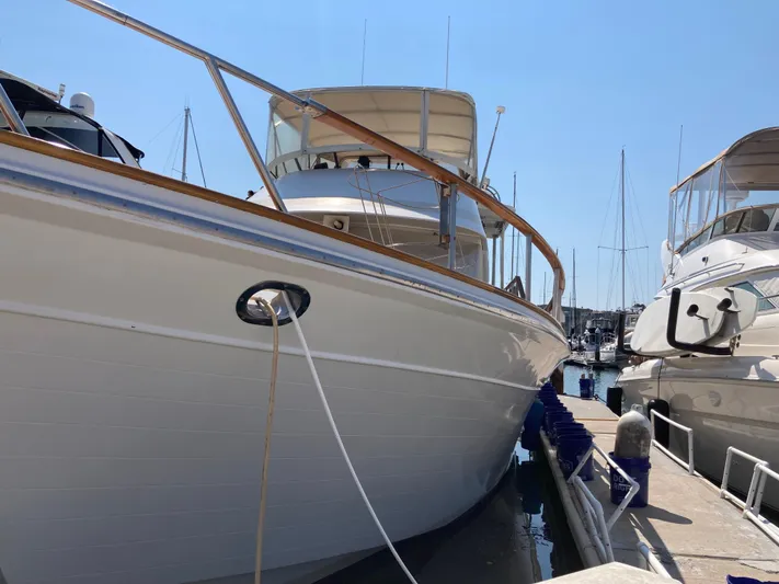  Yacht Photos Pics 1985 Offshore Yachts 48 Yachtfisher docked at marina, side view.