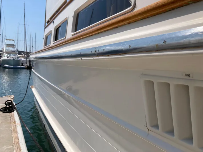  Yacht Photos Pics 1985 Offshore Yachts 48 Yachtfisher docked, showcasing sleek white hull and marina setting.