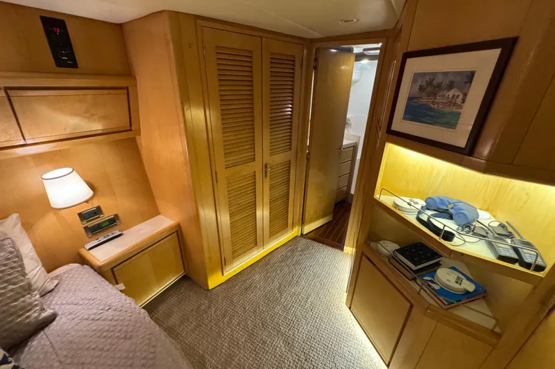  Yacht Photos Pics 1996 Bertam Convertible cabin interior with wooden finishes, cozy bed, and illuminated shelves.