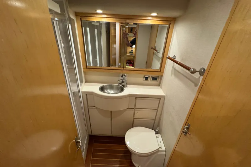  Yacht Photos Pics Bathroom interior of a 1996 Bertam Convertible yacht, featuring sink and toilet.