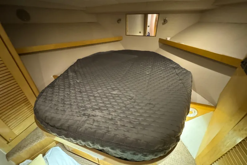  Yacht Photos Pics Cozy cabin interior of a 1996 Bertam Convertible boat with a quilted bedspread.