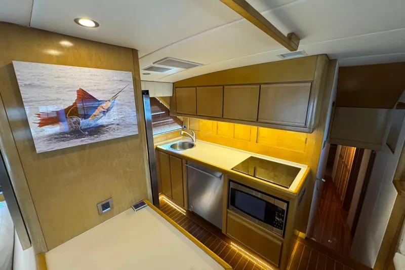  Yacht Photos Pics 1996 Bertam Convertible yacht kitchen with modern appliances and wooden cabinetry.