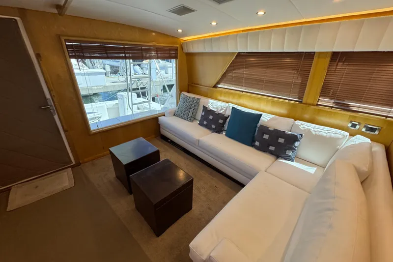  Yacht Photos Pics Interior of a 1996 Bertam Convertible yacht with white sofas and wooden accents.