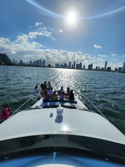  Yacht Photos Pics Group enjoying sunny day on 1997 Azimut 54 yacht, city skyline in background.