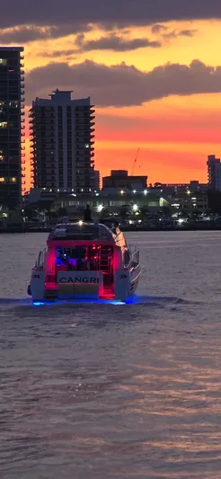  Yacht Photos Pics Azimut 54 yacht cruising at sunset with city skyline in the background.