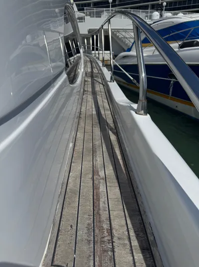  Yacht Photos Pics 1997 Azimut 54 yacht deck with wooden flooring and metal railings at a marina.