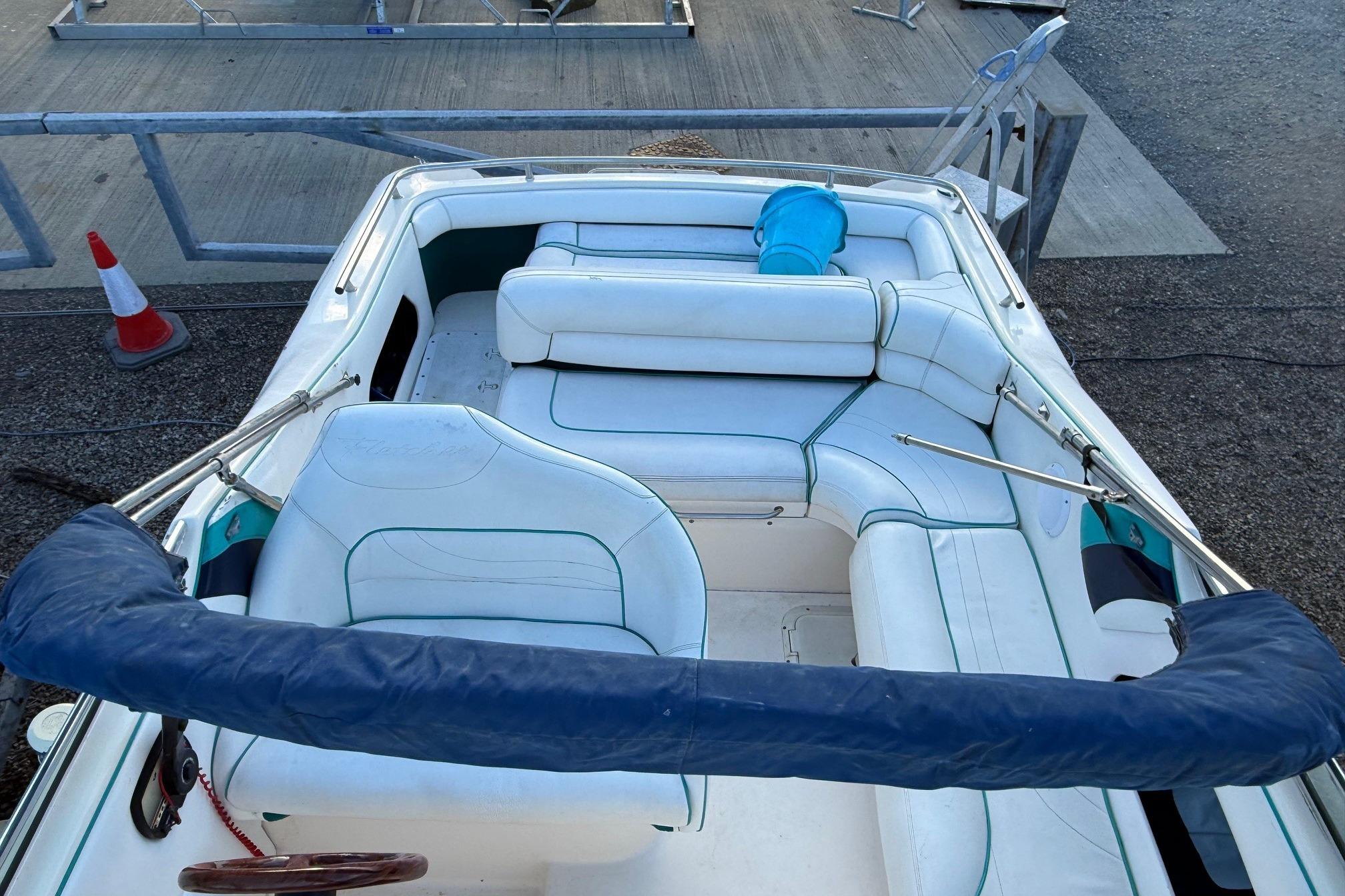 Fletcher Arrowbolt 25 boat interior, 2000 model, featuring white seating and blue accents.
